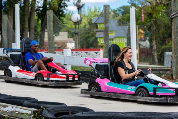 A woman and man race in go-karts.