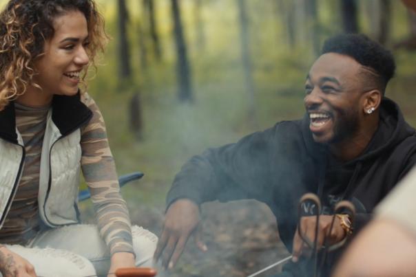 People sitting around campfire, laughing