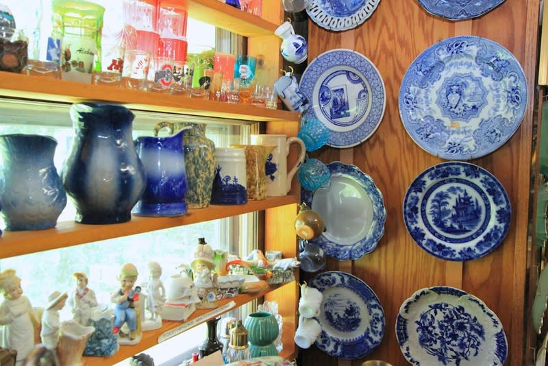 Vintage glass and plates are displayed on the wall and shelves.