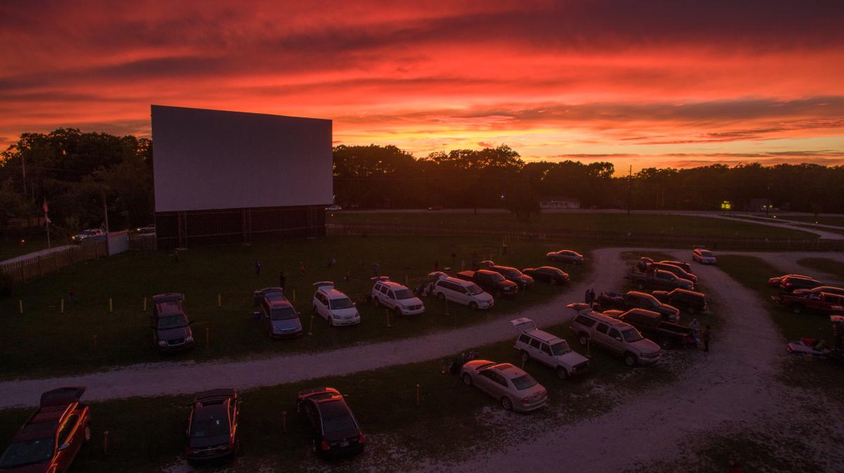 A beautiful sunset covers the sky in orange light at the 49er Drive-In Theater.