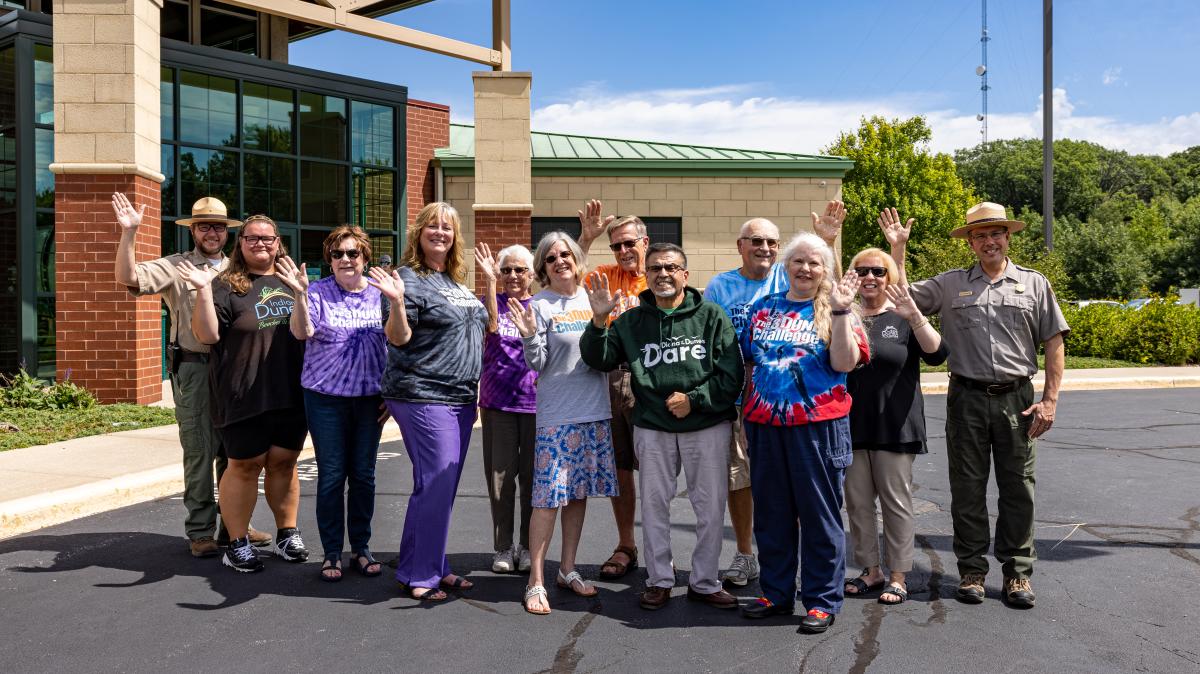 A group of people wave at the camera