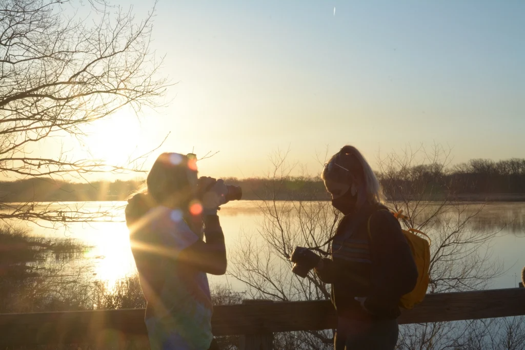students backlit against a sunrise
