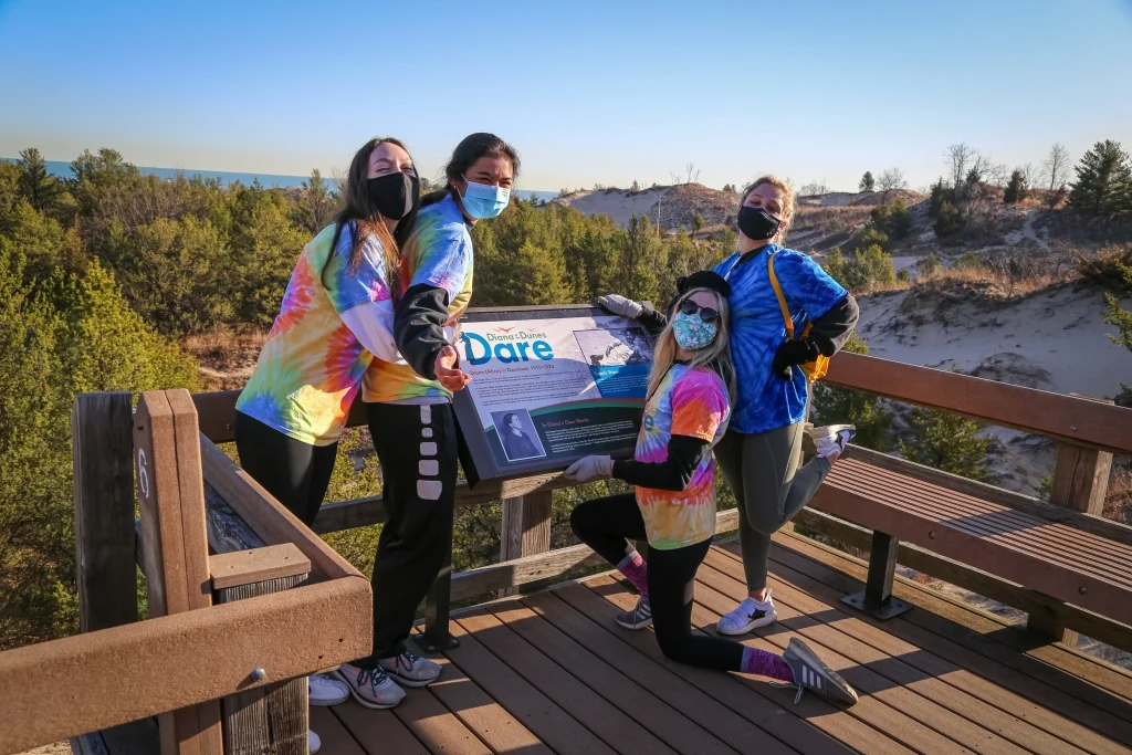Students next to a sign on the Diana of the Dunes Trail