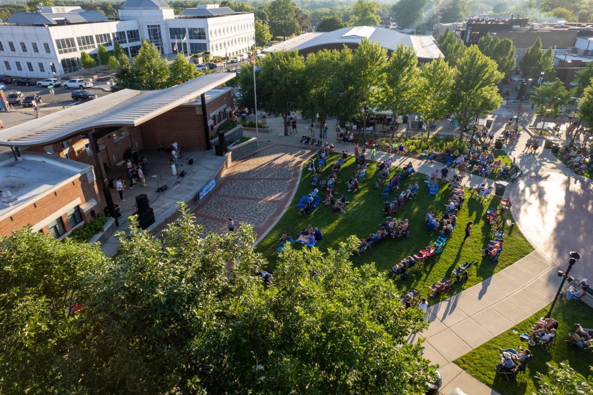 Aerial view of an outdoor stage with an audience and trees