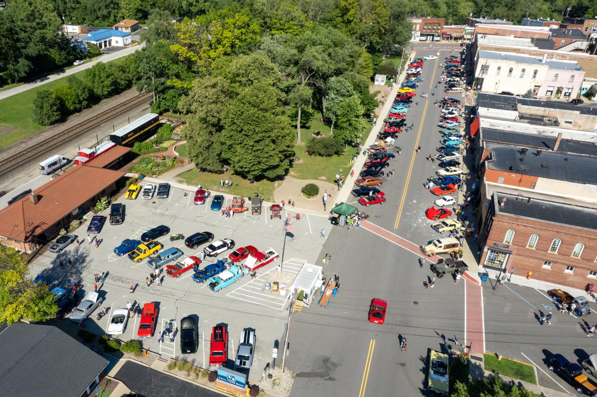 Aerial view of a small downtown. Classic cars are parked along the street.