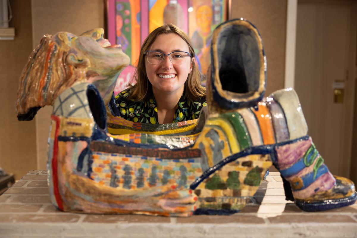 An artist's head lies above a sculpture of a reclining person in the Chesterton Art Center.