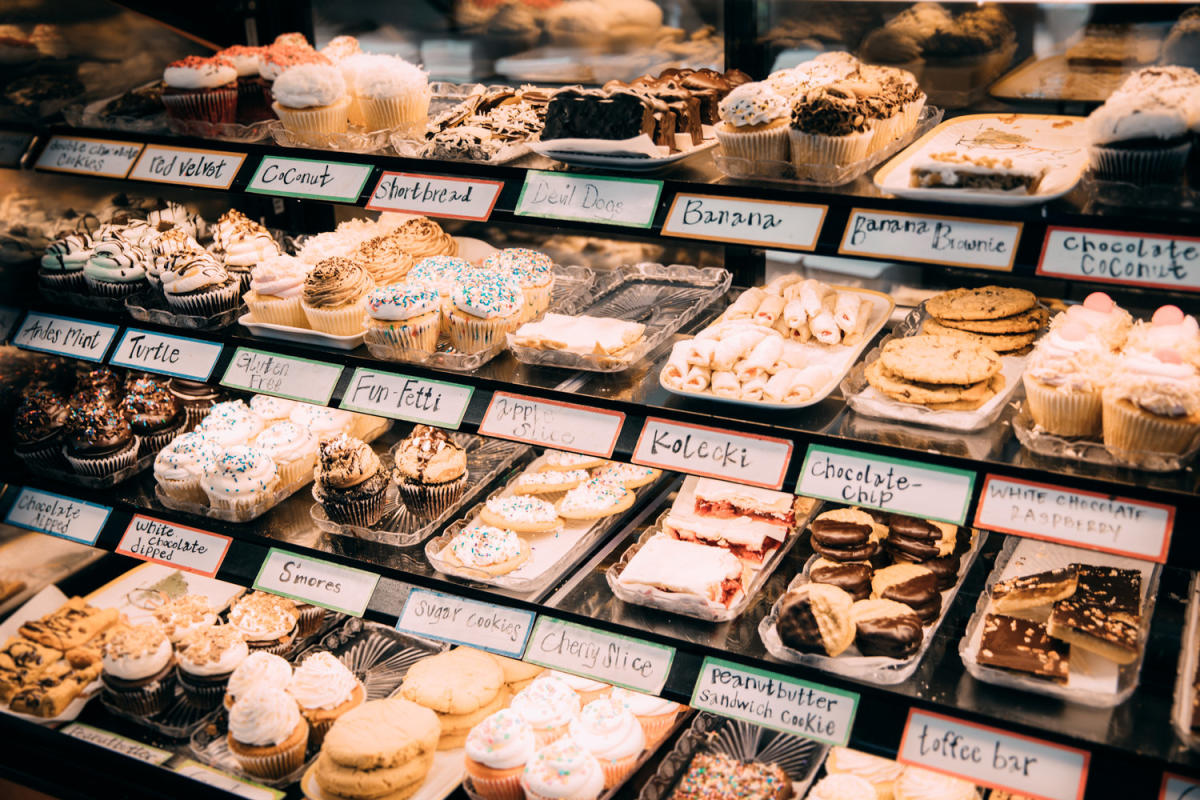 A dessert case is filled with colorful desserts, each with a label underneth.
