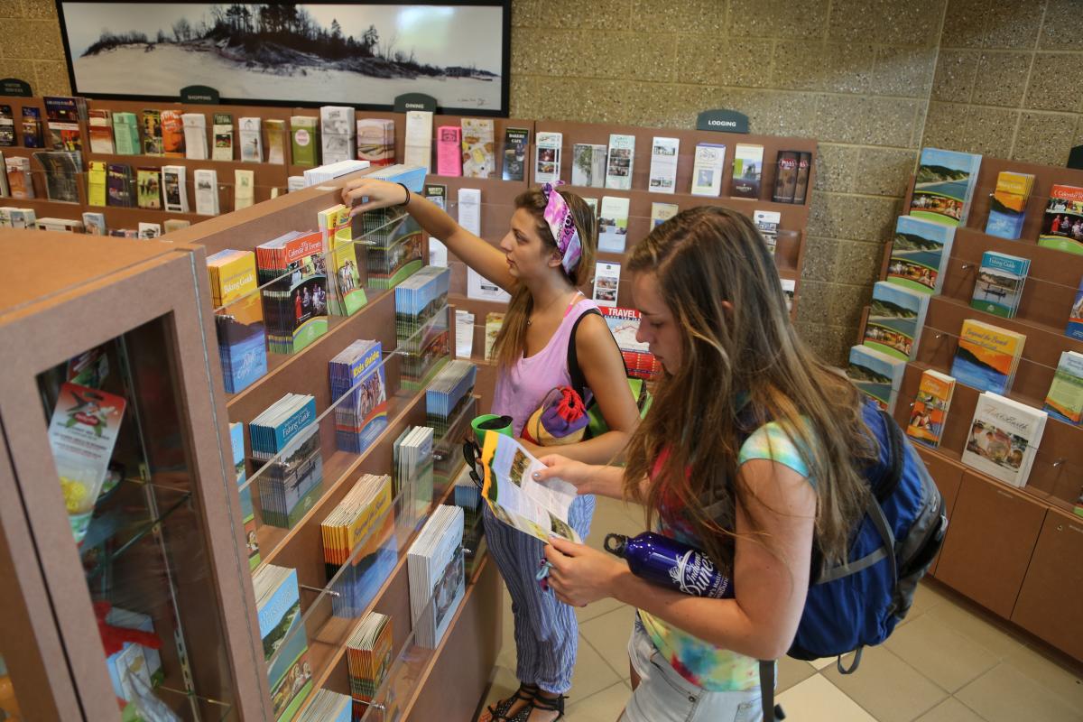 Two teenagers look at brochure racks