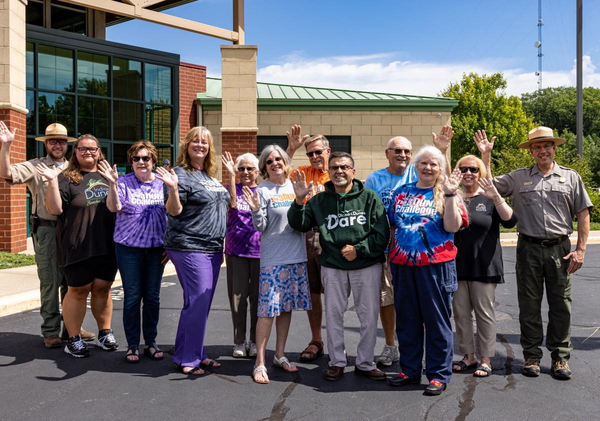 A group of people wave at the camera