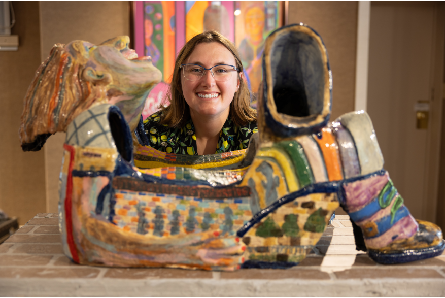 An artist's head lies above a sculpture of a reclining person in the Chesterton Art Center.