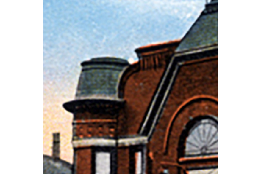 Historic architectural detail featuring a brick building and distinctive rooftop tower.