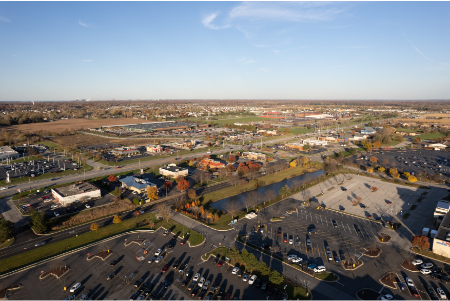 Aerial view of a downtown area with retail shops and parking lots