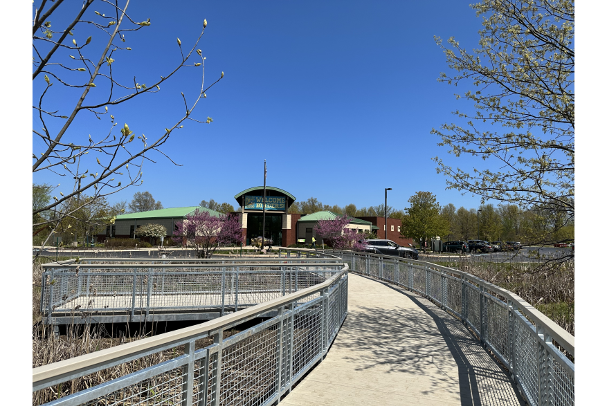 A boardwalk with railings leads up to a building