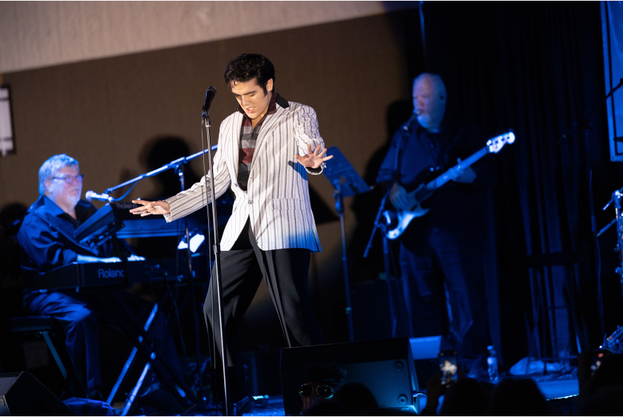 A man dressed like Elvis performs on stage