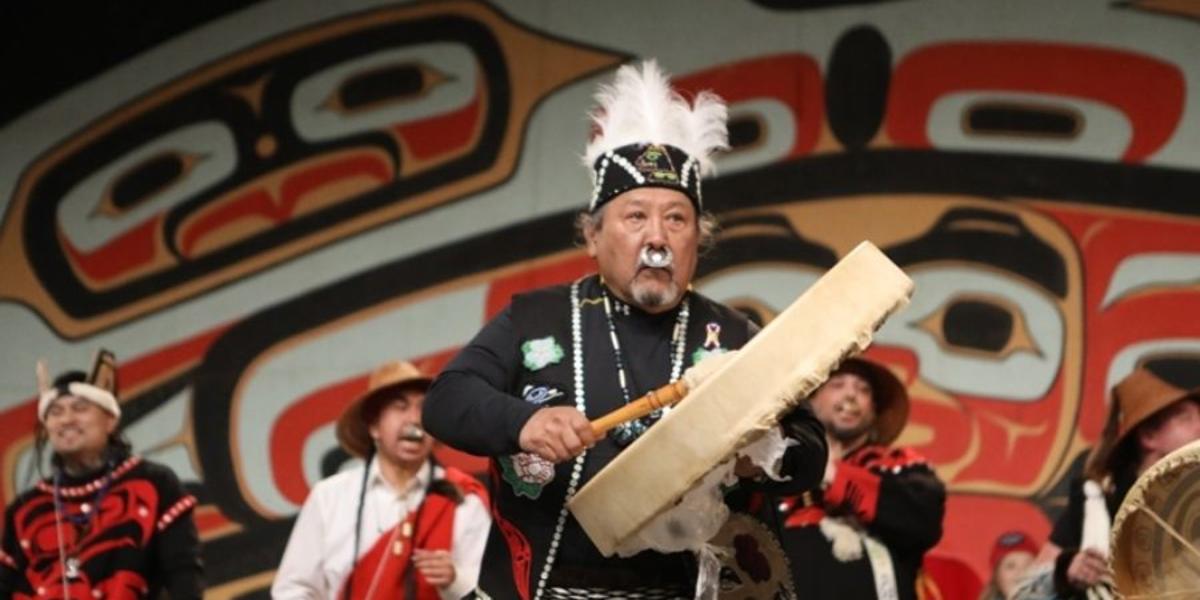 Alaska Natives dressed in regalia singing and dancing at Celebration.