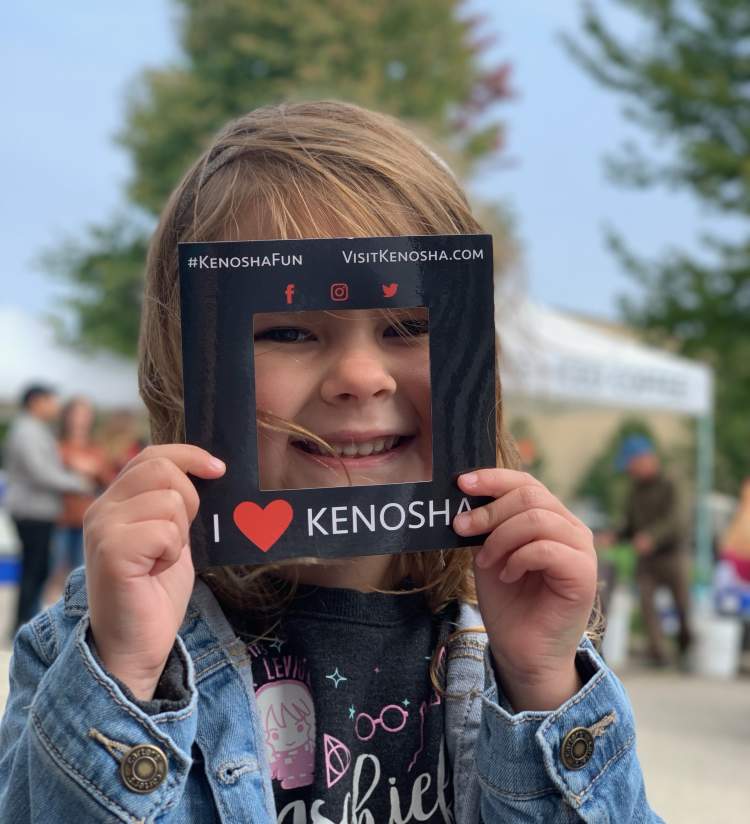 girl holding I Heart Kenosha frame