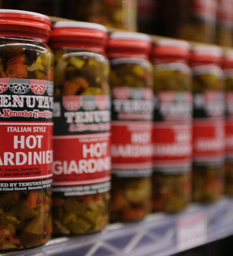 Shelf full of glass jars containing "hot giardiniera" at Tenuta's Delicatessen and Liquors