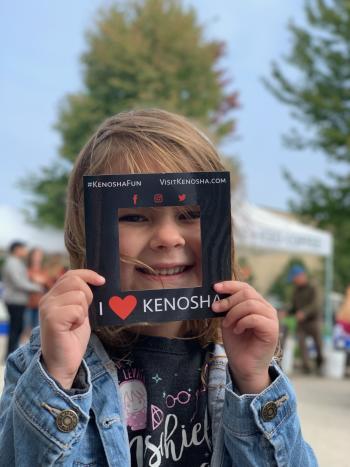girl holding I Heart Kenosha frame