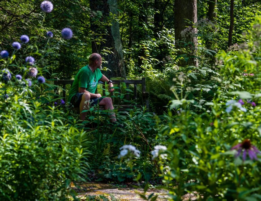 Person sitting on a bench in the Hathorn Hallow's garden