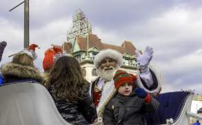 Santa and child waiving while sitting in a sleigh