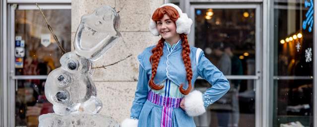 A woman dressed as Ana from "Frozen" standing in front of Olaf ice sculpture at the Downtown on Ice Festival in Downtown Scranton, PA