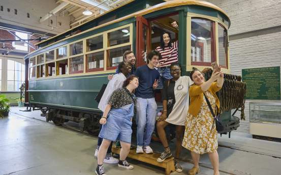 A group of people taking a selfie on a trolley car at the Electric City Trolley Station & Museum in Downtown Scranton, PA