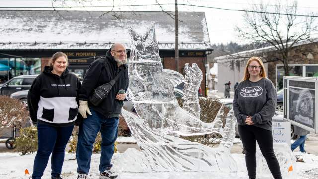 A family posing next to an ice sculpture at the Clarks Summit Festival of Ice in Clarks Summit, PA
