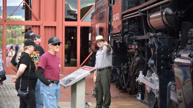 National Park Service Ranger speaking with guests in front of a locomotive at Steamtown National Historic Site in Scranton, PA