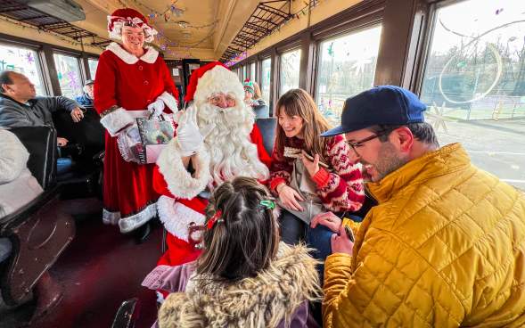 Santa and Mrs. Claus visiting with a family on the North Pole Limited train ride at the Steamtown National Historic Site in Downtown Scranton, PA
