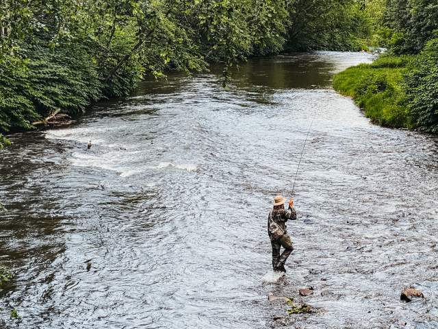A man fishing in the Lackawanna River