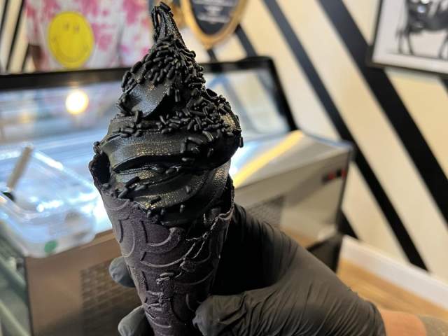 Black Cow Cookies & Cream on top of a black cone.