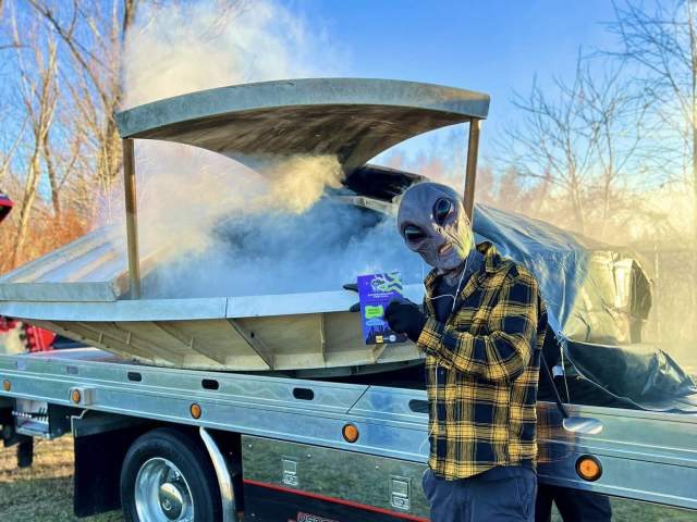 A man posing for a photo in front of a "spaceship" while dressed as an alien at the Carbondalien Festival in Carbondale, PA