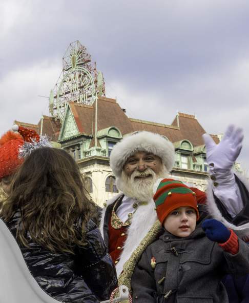 Santa and child waiving while sitting in a sleigh