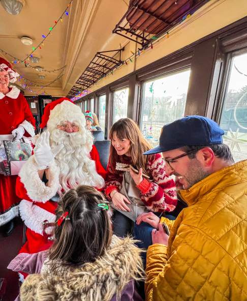 Santa and Mrs. Claus visiting with a family on the North Pole Limited train ride at the Steamtown National Historic Site in Downtown Scranton, PA