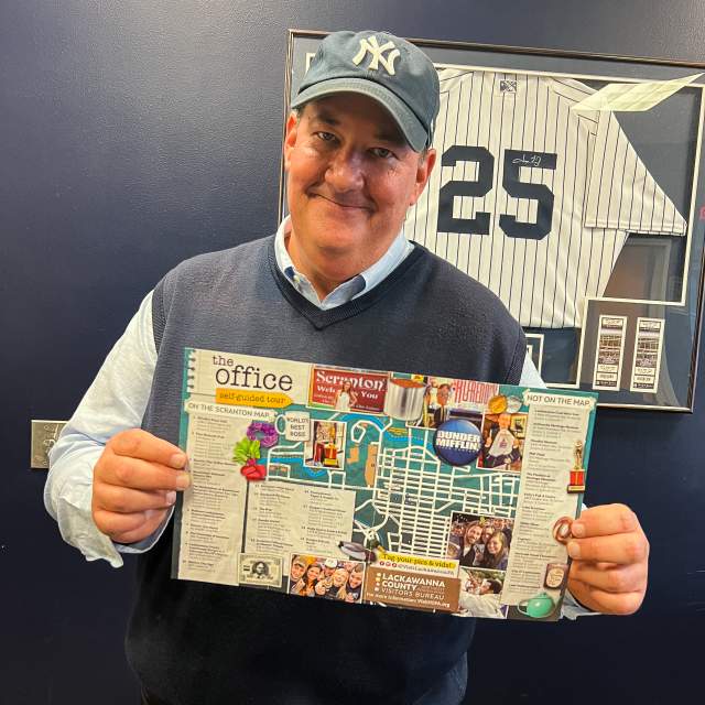 Brian Baumgartner (aka Kevin from The Office tv show) holding The Office Self-Guided Tour map