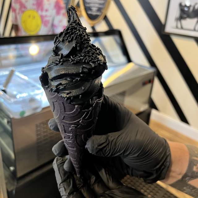 Black Cow Cookies & Cream on top of a black cone.