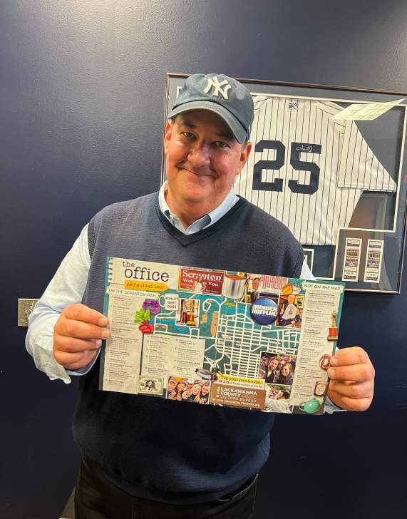 Brian Baumgartner (aka Kevin from The Office tv show) holding The Office Self-Guided Tour map