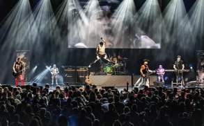 the M80's band performing on stage in front of a crowd