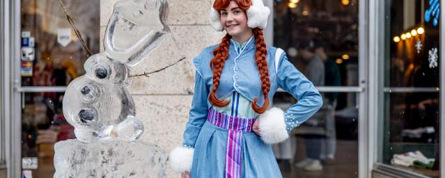 A woman dressed as Ana from "Frozen" standing in front of Olaf ice sculpture at the Downtown on Ice Festival in Downtown Scranton, PA