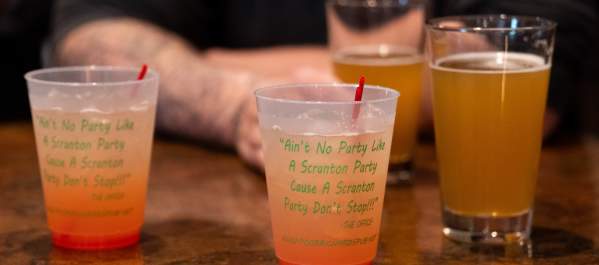 Cocktails in The Office quote cups and pints of beer on the bar at Poor Richard’s Pub in Scranton.