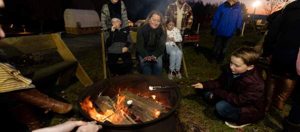 People roasting marshmallows around a campfire at Roba Family Farms