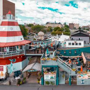 Cooper's Seafood House restaurant with a lighthouse and pirate ship design, featuring outdoor seating, decorations, and a large octopus sculpture on the top deck.