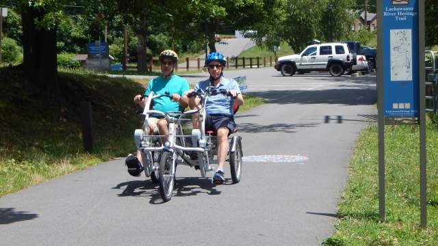 Two adults riding a bicycle on the Lackawanna River Heritage Trail in Scranton, PA