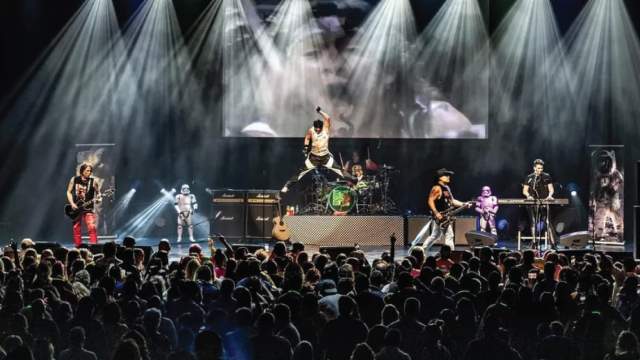 the M80's band performing on stage in front of a crowd