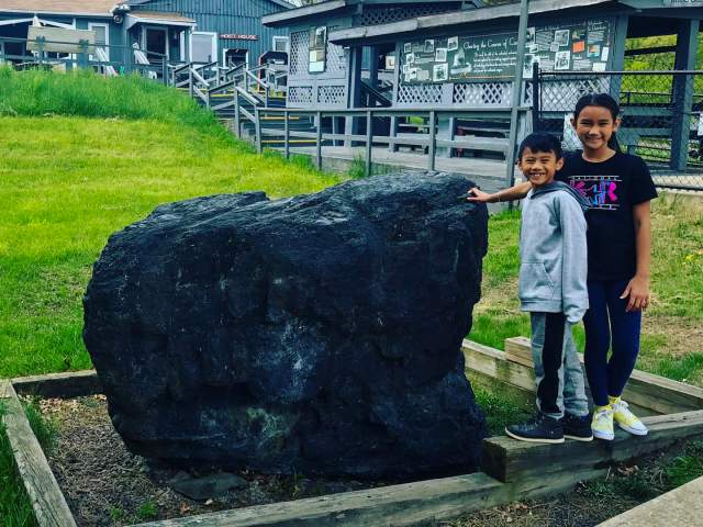 Kids posing for a photo in front of large piece of anthracite at the Lackawanna Coal Mine Tour in Scranton, PA