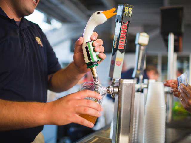 An employee pouring a cup of beer at an SWB RailRiders game in Moosic, PA