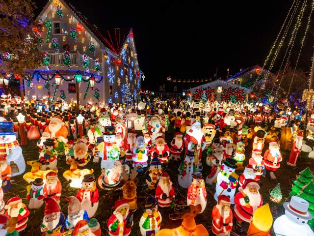 Peckville Christmas House with illuminated holiday lights and lighted toy displays at night.