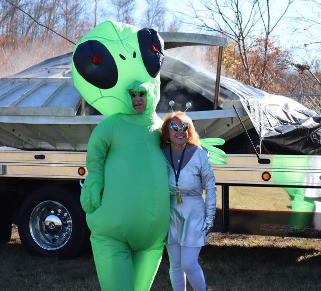 A couple dressed in alien costumes standing in front of a spaceship at The Carbondalien Festival in Carbondale, PA