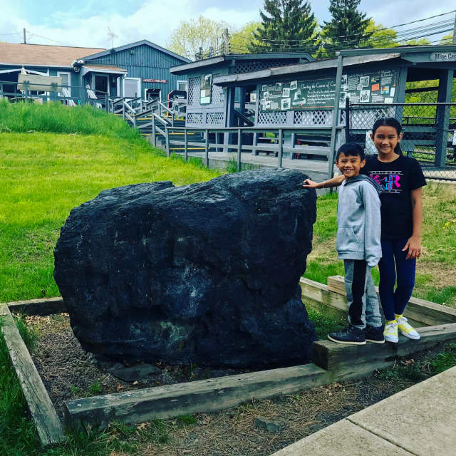 Kids posing for a photo in front of large piece of anthracite at the Lackawanna Coal Mine Tour in Scranton, PA