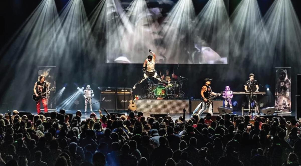 the M80's band performing on stage in front of a crowd